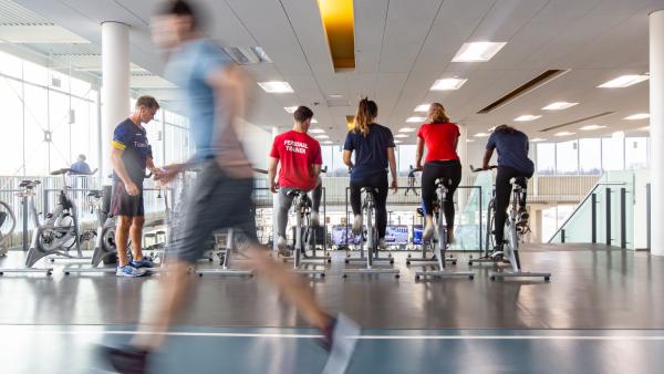 Students running and using stationary bikes at the Recreation, Athletic & Wellness Centre 