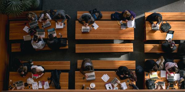 Students using laptops on tables.