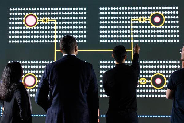 Four people analyzing a data model on a large screen