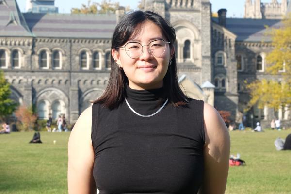 Photo of U of T student in front of University College building