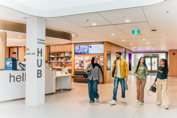Students walking in front of welcome desk.