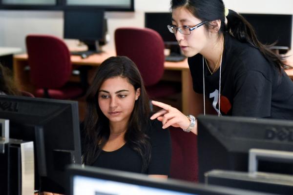 Two students talking about what they're seeing on their computer screen