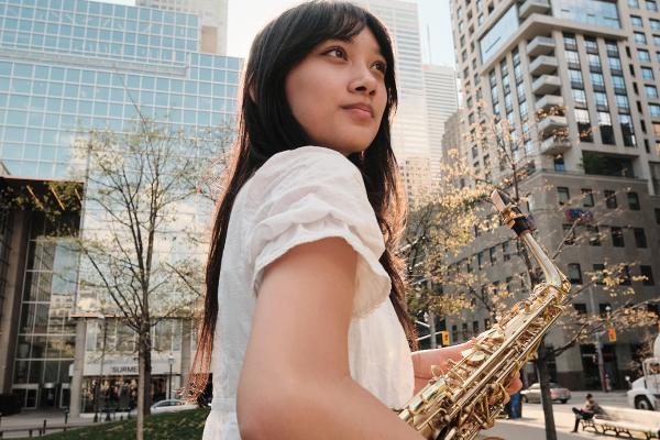Bea holding saxophone in park