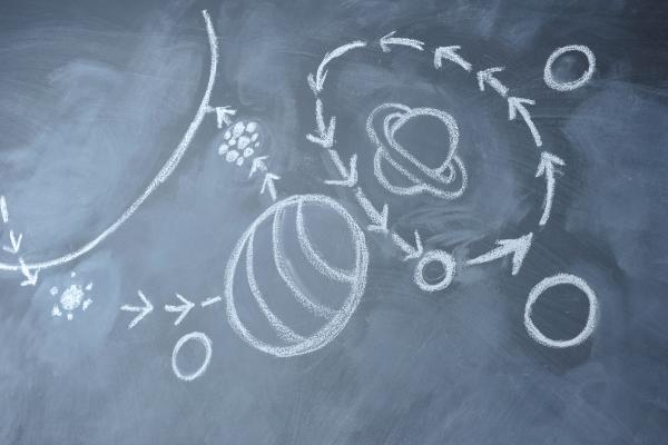 Chalk drawing of planets and orbital paths on a blackboard