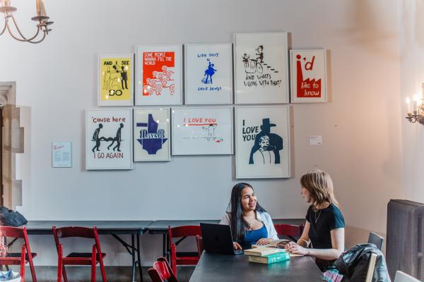 Two students sitting and talking together at a table.