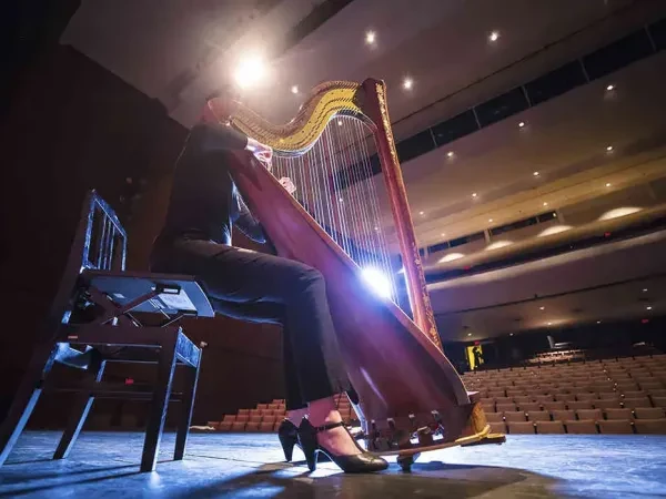 A woman playing hart on stage to an empty auditorium