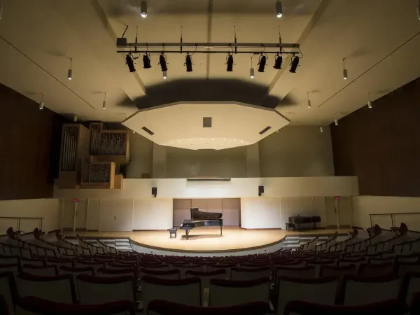 Empty theatre with a well-lit piano on stage