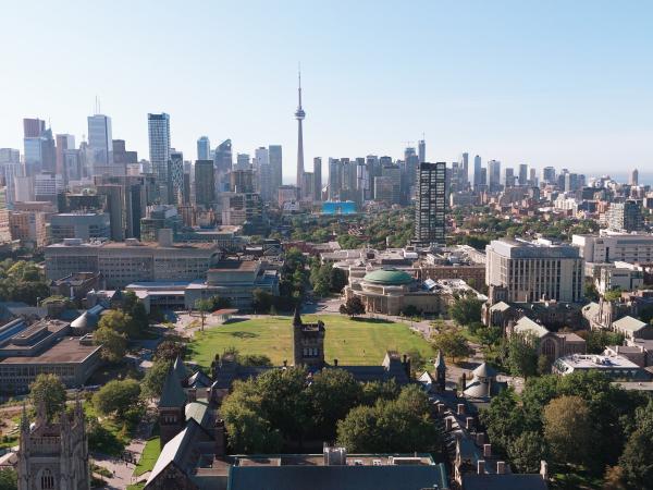 Aerial view of the U of T St. George campus in downtown Toronto, with historic buildings in the foreground and the CN Tower and city skyline in the background