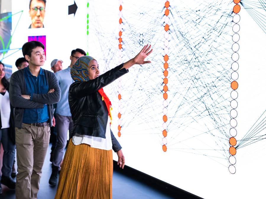 Students standing in front of large touchscreen