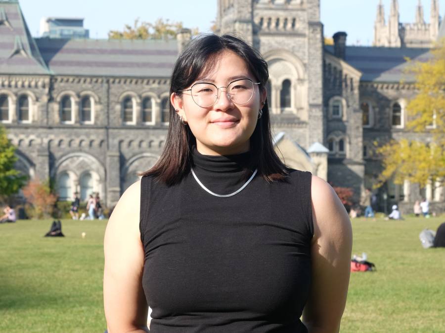 Photo of U of T student in front of University College building