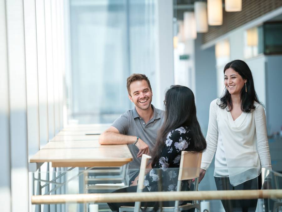 Staff sitting at a desk and chatting.