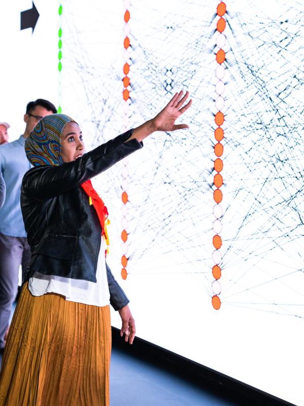 Students standing in front of large touchscreen