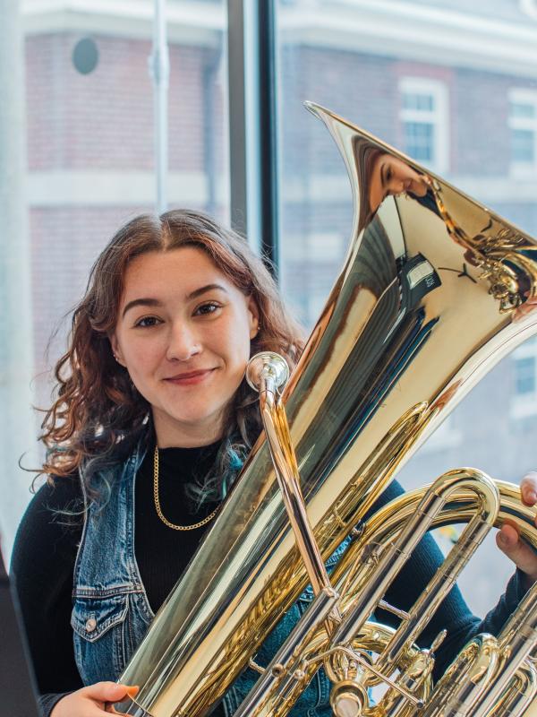 A music student posing with her tuba