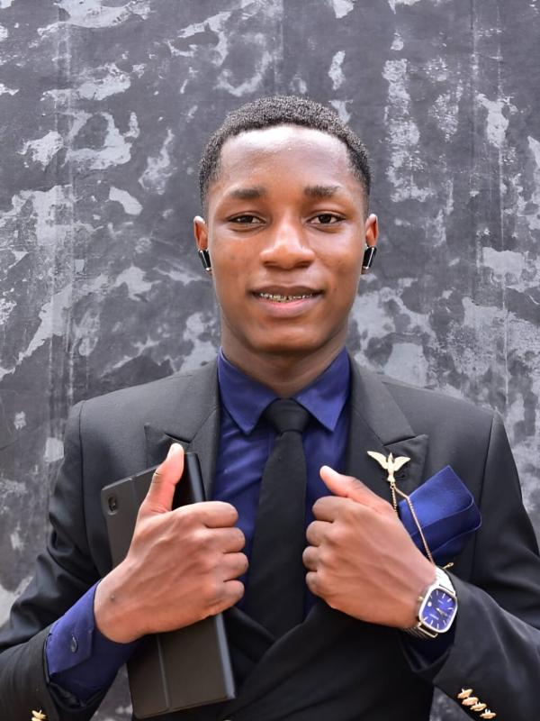 Student wearing a black suit and blue shirt