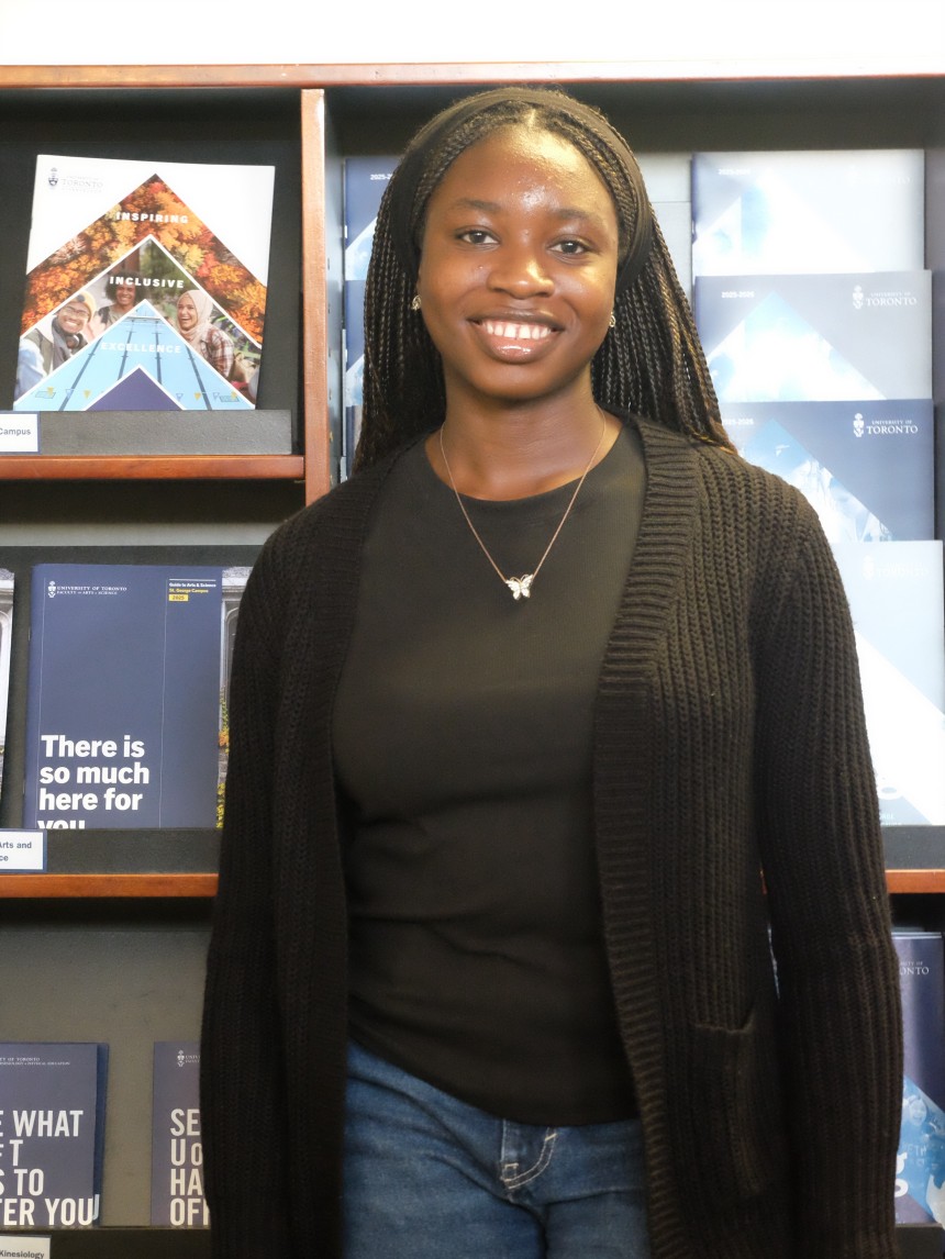 U of T student in front of viewbooks
