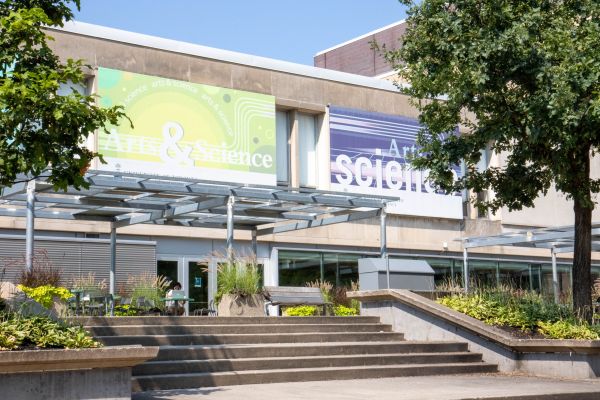 Trees in front of a building with a big sign that says Arts & Science