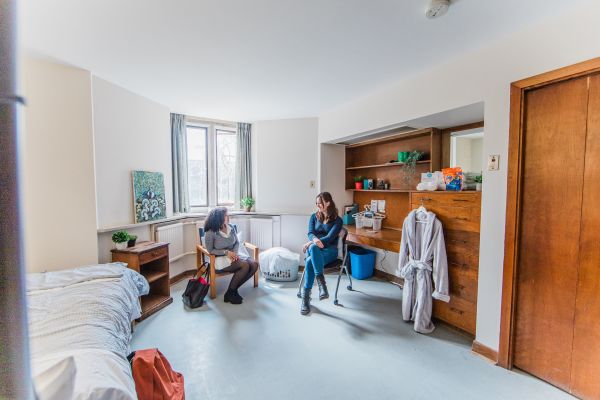 Two students sitting and talking to one another in residence