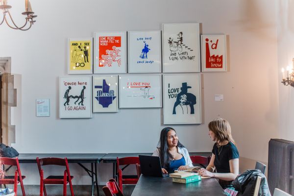 Two students sitting and talking together at a table.