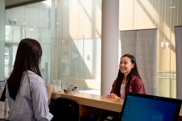 A student standing at the desk at the UTSC Office of the Registrar