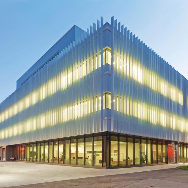 A modern building in the evening with lights shining through from the inside