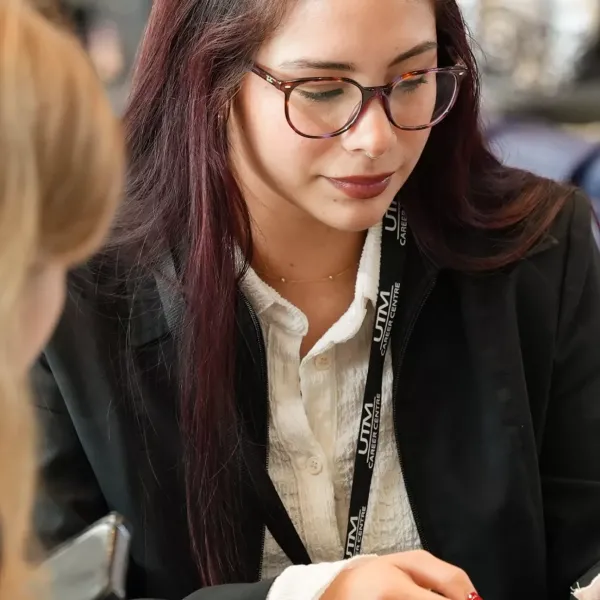 Two students in suits sitting next to each other.