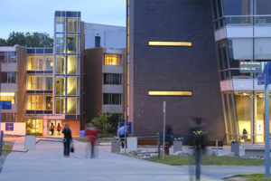 Students walking at dusk in front of a building at U of T Scarborough